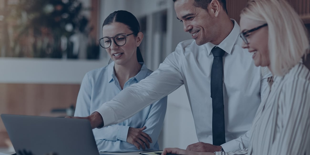 People in business clothes looking at a laptop