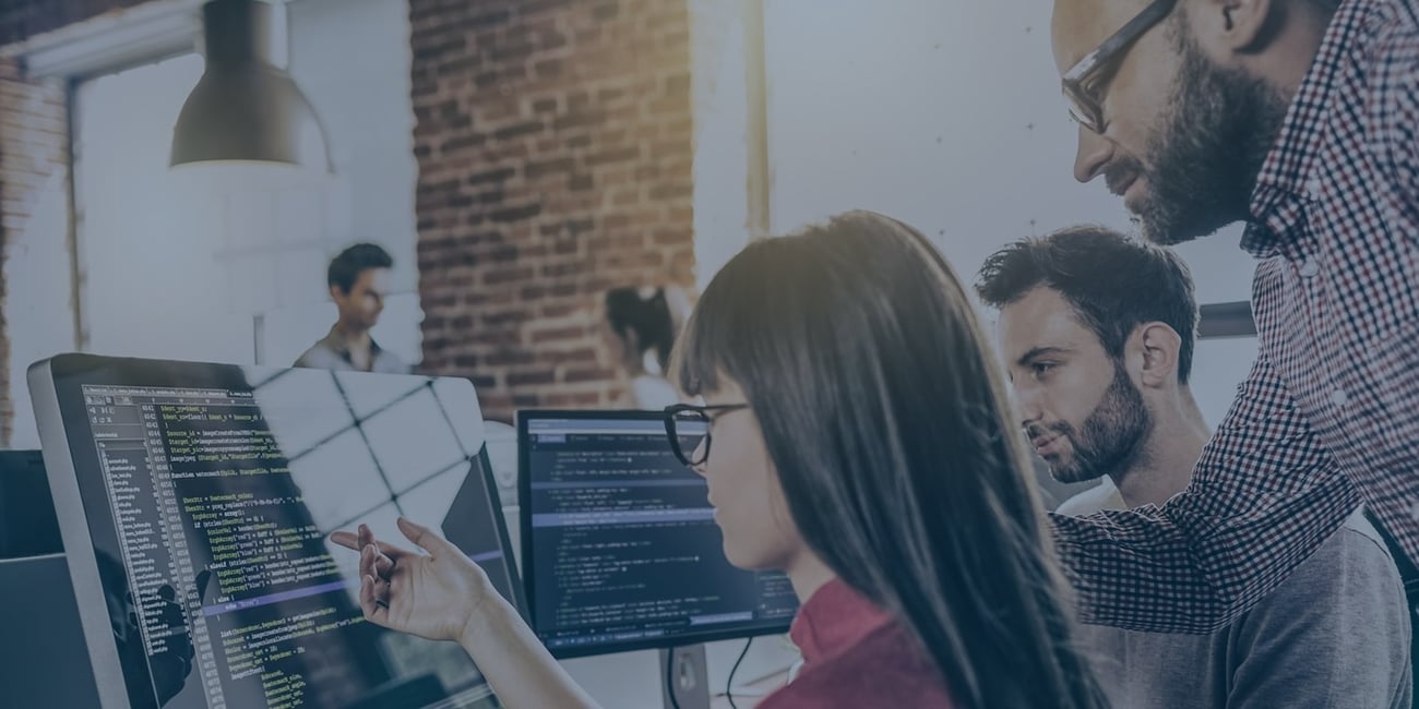 People looking at screens with code on it